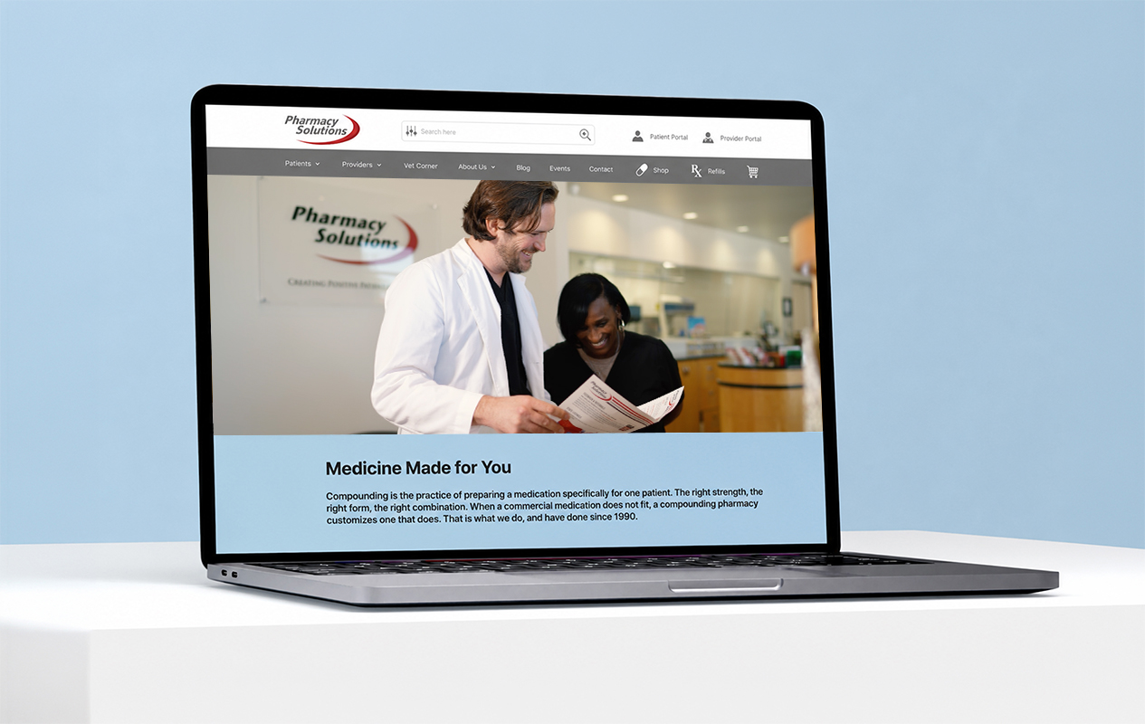 Laptop displaying the Pharmacy Solutions website on a light blue background